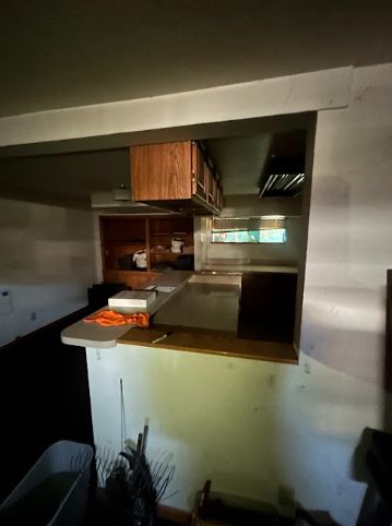 Dark and dated basement kitchen needing extensive repairs