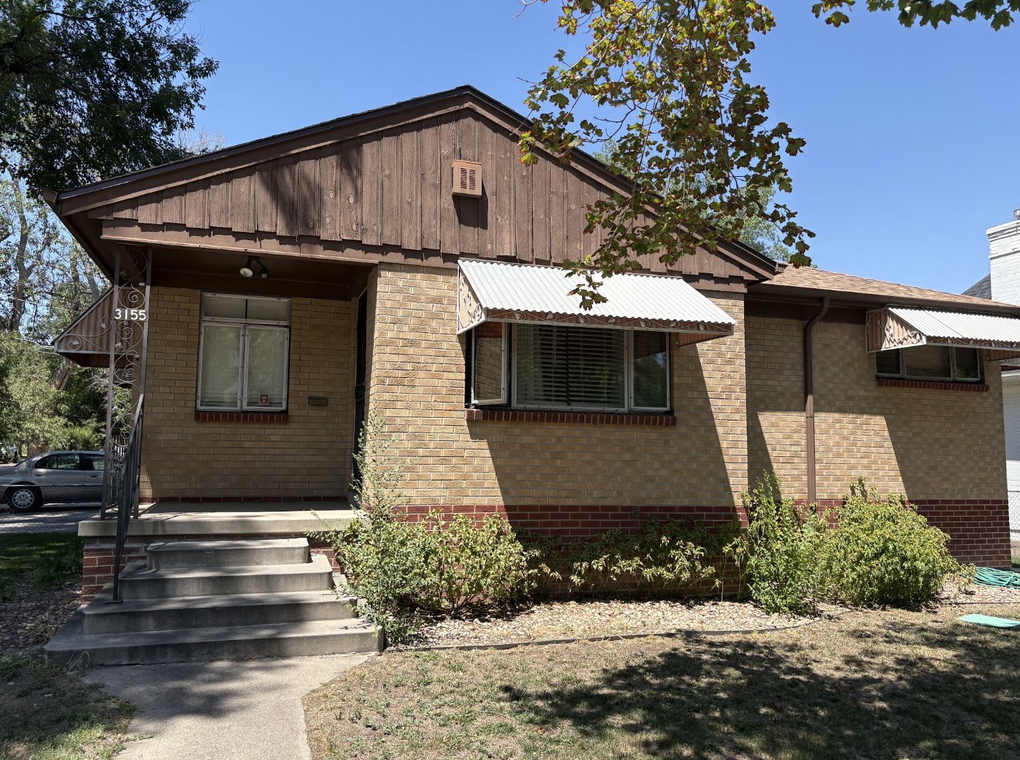 Exterior of a dated brick Colorado home purchased as-is